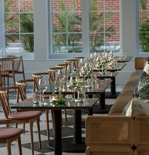 Elegant matsal med dukade bord, glas, bestick och tända ljus